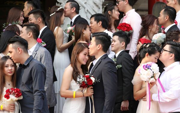 Молодожены целуются во время массовой свадьбы в Куала-Лумпуре, Малайзия - Sputnik Азербайджан