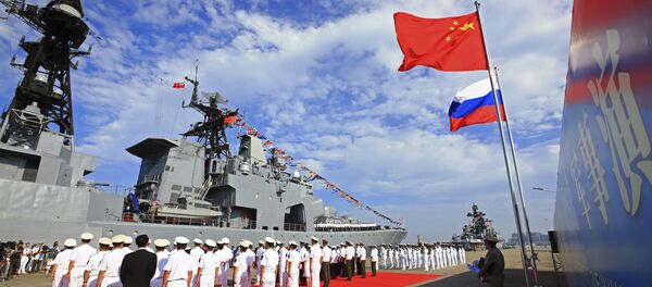Офицеры и моряки ВМС Народной Освободительной Армии Китая проводят церемонию приветствия, когда российский военный корабль прибывает в порт в Чжаньцзяне в провинции Гуандун на юге Китая - Sputnik Азербайджан