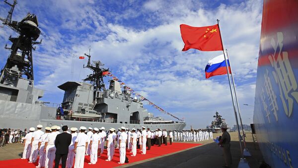 Офицеры и моряки ВМС Народной Освободительной Армии Китая проводят церемонию приветствия, когда российский военный корабль прибывает в порт в Чжаньцзяне в провинции Гуандун на юге Китая - Sputnik Азербайджан