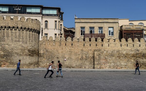 Молодые люди играют в футбол в Старом городе в Баку - Sputnik Азербайджан
