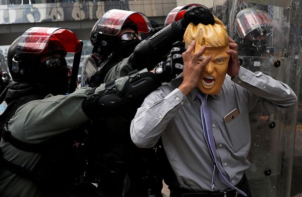 Антиправительственный демонстрант в маске президента США Дональда Трампа во время демонстраций в Гонконге - Sputnik Азербайджан