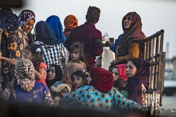 Сирийские арабские и курдские мирные жители бегут от турецких бомбардировок сирийского города Рас-эль-Айн на границе с Турцией - Sputnik Азербайджан
