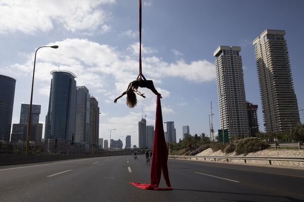 Израильская акробатка выступает на шоссе во время еврейского праздника Yom Kippur в Тель-Авиве, Израиль - Sputnik Азербайджан