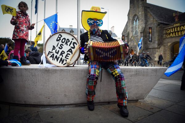 Демонстрант в костюме играет на аккордеоне, ожидая участия в марше за независимость Шотландии в Эдинбурге - Sputnik Азербайджан