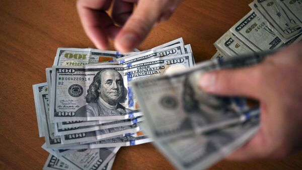 Человек считает доллары, фото из архива - Sputnik Azərbaycan