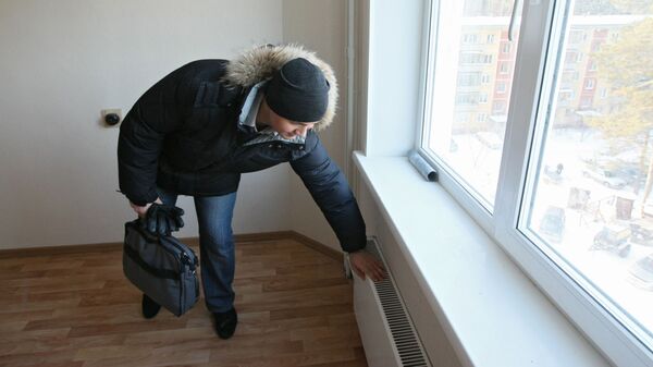 Парень проверяет отопление, фото из архива - Sputnik Азербайджан