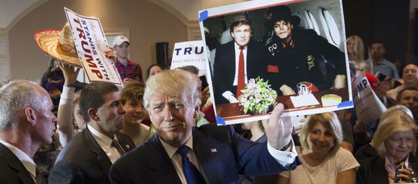 Дональд Трамп держит фотографию себя с покойным поп-певцом Майклом Джексоном Дональд Трамп держит фотографию себя с покойным поп-певцом Майклом Джексоном - Sputnik Азербайджан