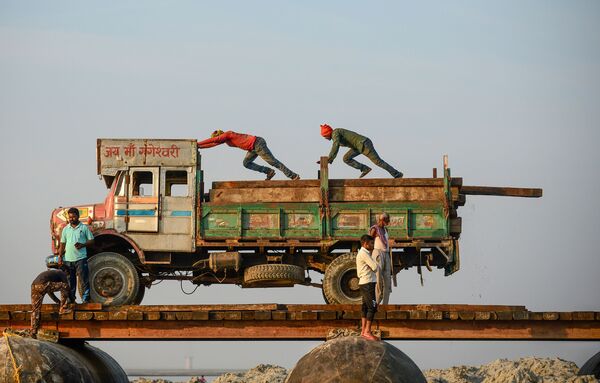 Рабочие во время строительства временного понтонного моста через Ганг в Аллахабаде, Индия - Sputnik Азербайджан