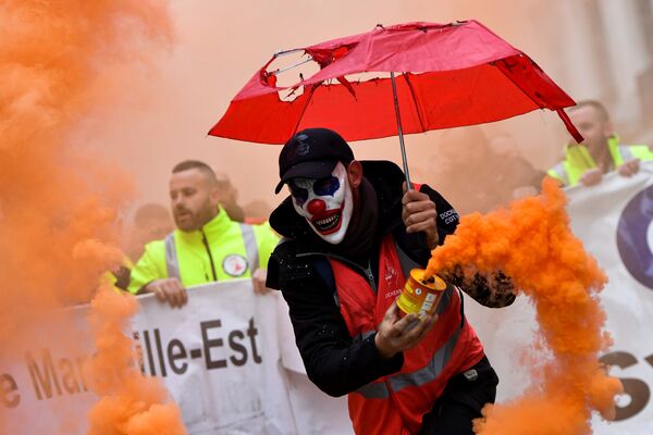 Мужчина в маске клоуна с дымовой шашкой во время протеста против пенсионной реформы в Марселе, Франция - Sputnik Азербайджан