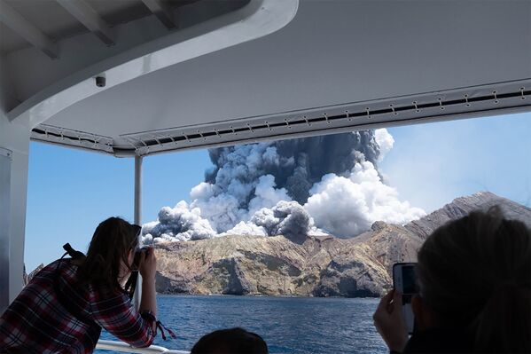 Туристы снимают извержение вулкана на острове Уайт-Айленд в Новой Зеландии - Sputnik Азербайджан