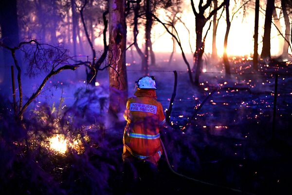 Пожарный использует встречный пал во время пожаров в Австралии - Sputnik Азербайджан