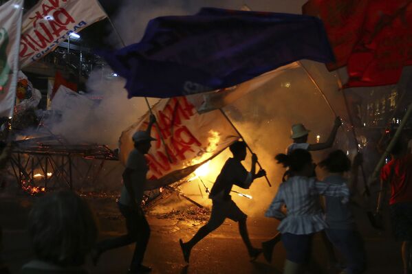 Протестующие вокруг горящего изображения президента Филиппин Родриго Дутерте во время митинга возле президентского дворца в Маниле - Sputnik Азербайджан