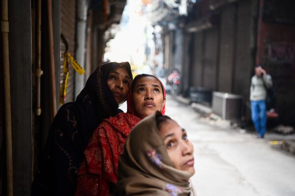 Женщины смотрят на пожар на фабрике в Нью-Дели, Индия - Sputnik Азербайджан