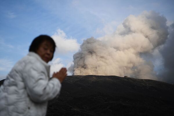 Женщина на фоне действующего вулкана в городе Асо в префектуре Кумамото - Sputnik Азербайджан