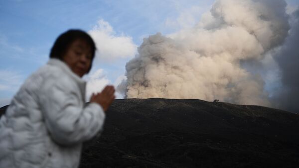 Женщина на фоне действующего вулкана в городе Асо в префектуре Кумамото - Sputnik Azərbaycan