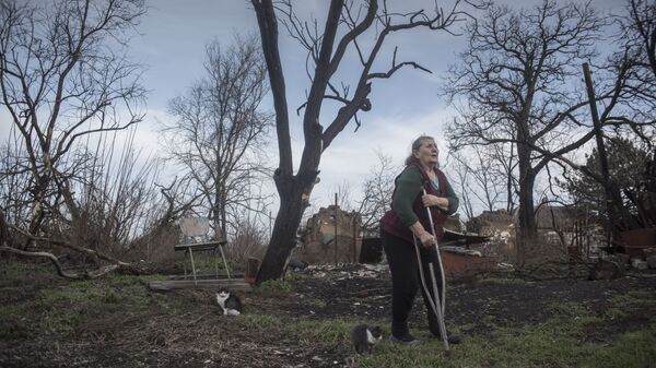 Местная жительница возле обломков здания в Донецкой области - Sputnik Азербайджан