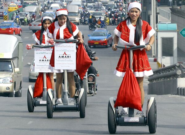 Работницы отеля в костюмах Санта-Клауса во время раздачи подарков в Бангкоке  - Sputnik Азербайджан