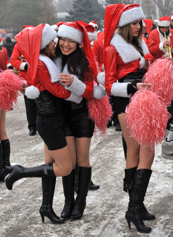 Девушки в костюмах Санта-Клауса во время новогоднего парада в Бишкеке  - Sputnik Азербайджан