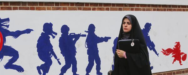 Иранка на фоне граффити у бывшего здания посольства США в Тегеране, фото из архива Иранка на фоне граффити у бывшего здания посольства США в Тегеране, фото из архива - Sputnik Азербайджан
