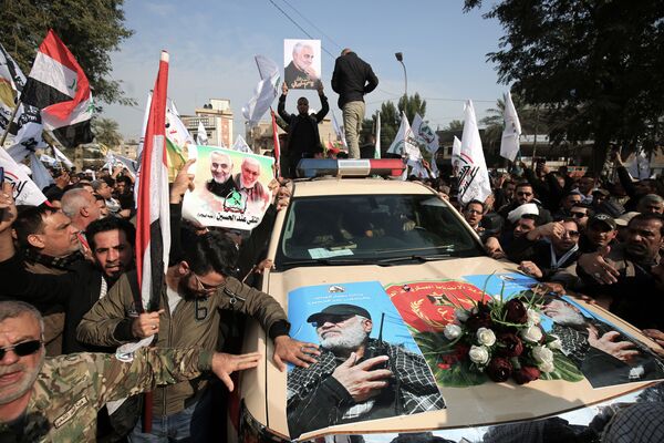 Машина с изображениями иракского военного Абу Махди аль-Мухандис во время похоронной церемонии в Багдаде - Sputnik Азербайджан