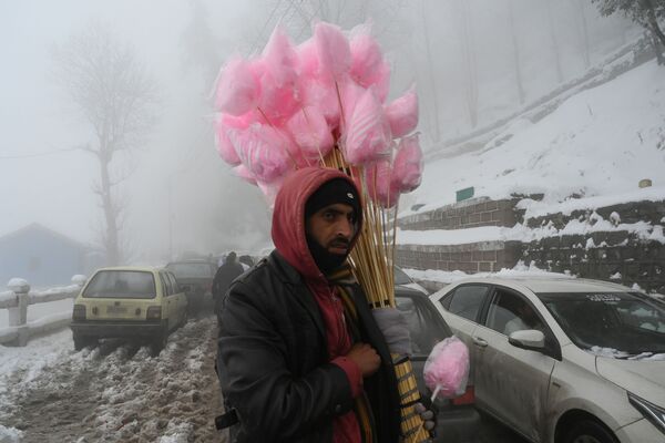 Продавец сладостей во время снегопада, Пакистан - Sputnik Азербайджан