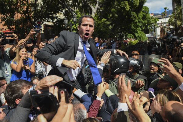 Самопровозглашенный исполняющий обязанности президента Венесуэлы Хуан Гуайдо в окружении журналистов по пути в Национальное собрание, Каракас - Sputnik Азербайджан