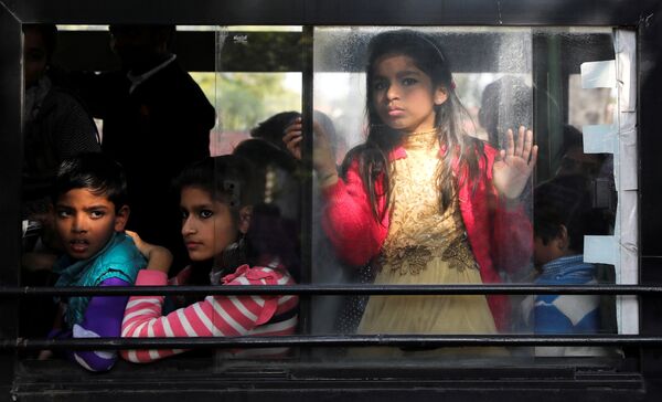 Пассажиры автобуса  наблюдают за акцией протеста против нового закона о гражданстве, Нью-Дели, Индия - Sputnik Азербайджан