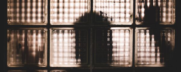 Силуэт человека за стеклянными блоками Силуэт человека за стеклянными блоками - Sputnik Азербайджан