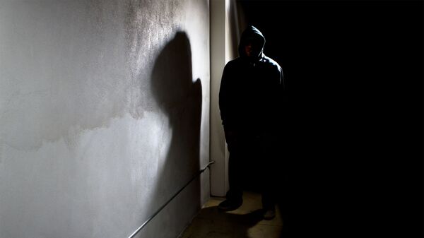 Мужчина в капюшоне прячется в тени улицы - Sputnik Азербайджан