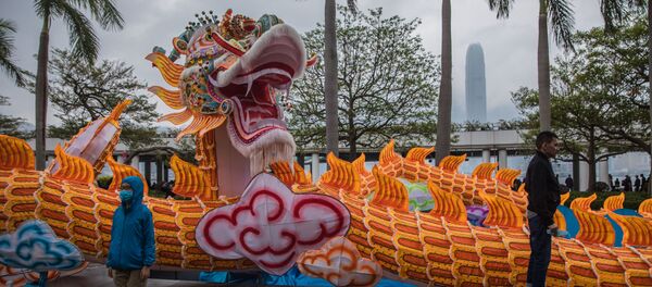 Мальчик в маске позирует для фотографии с изображением дракона в первый день Лунного Нового года в Гонконге - Sputnik Азербайджан