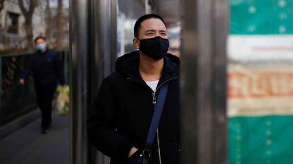 Мужчина в медицинской маске на автобусной остановке в Пекине, Китай, 27 января 2020 года - Sputnik Азербайджан