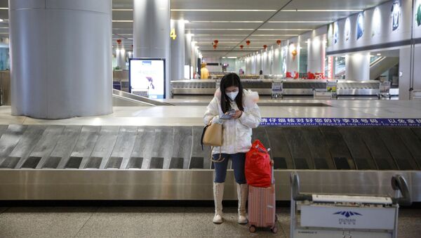 Женщина в медицинской маске в пустом зале для получения багажа в аэропорту Чанши провинции Хунань, Китай, 27 января 2020 - Sputnik Azərbaycan