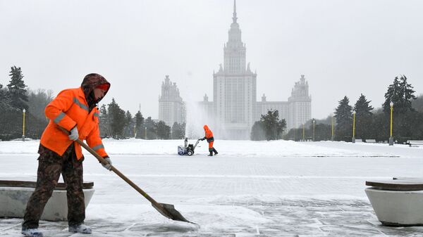 Сотрудники коммунальной службы во время уборки снега возле здания МГУ на Воробьевых горах в Москве - Sputnik Азербайджан