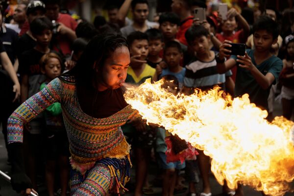 Уличная артистка выдувает огонь изо рта на праздновании Китайского нового года в Маниле, Филиппины - Sputnik Азербайджан