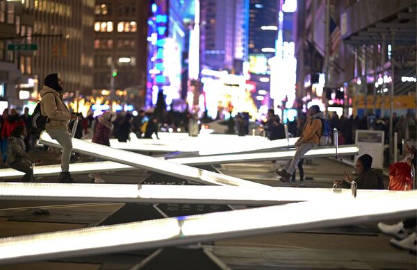Люди катаются на светящихся качелях на Бродвее недалеко от Тайм-сквер в Нью-Йорке - Sputnik Азербайджан