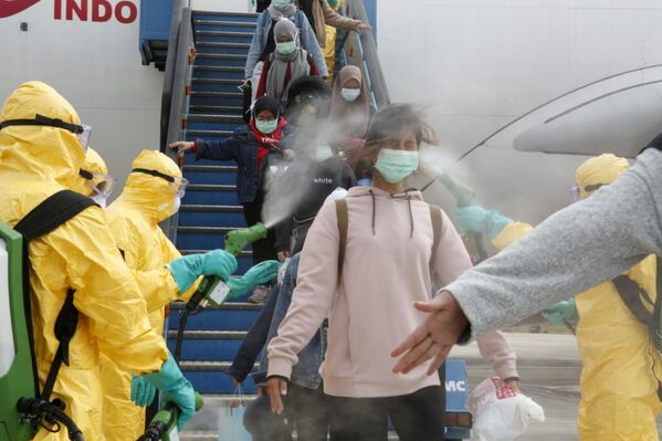 Медики опрыскивают индонезийских граждан антисептиком после прибытия из китайского Уханя, центра эпидемии коронавируса - Sputnik Азербайджан