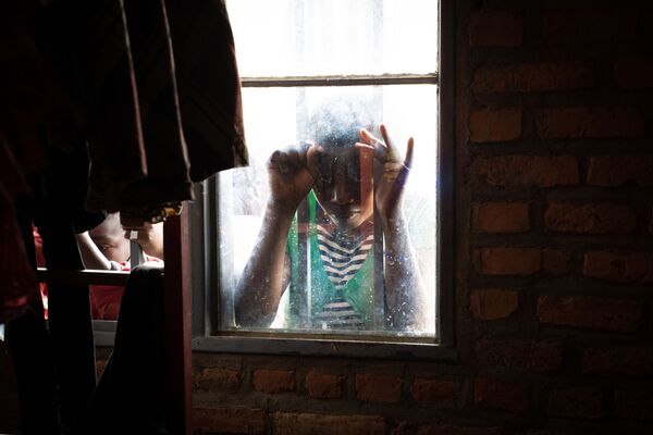 Девушка в окне центра для переселенцев в Ньярушиши, Руанда  - Sputnik Азербайджан