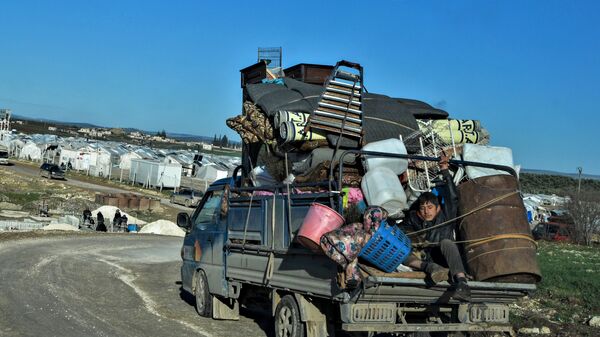 Сирийские беженцы прибывают в лагерь для внутренне перемещенных лиц недалеко от турецкой границы в удерживаемой повстанцами части провинции Алеппо - Sputnik Азербайджан
