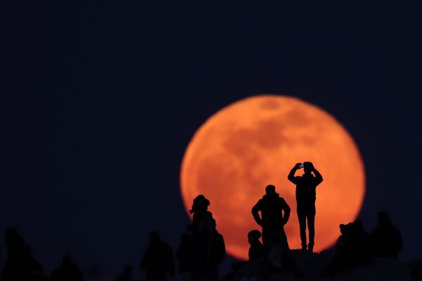 Люди наблюдают за восходом полной луны с места археологических раскопках Акрополя в Афинах, Греция - Sputnik Азербайджан