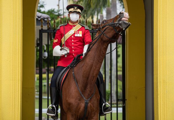 Королевский гвардеец в защитной маске в Национальном дворце в Куала-Лумпуре - Sputnik Азербайджан