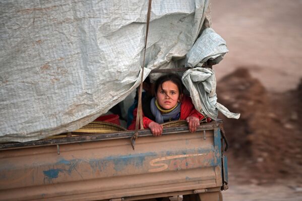 Сирийская беженка едет в кузове грузовика вдоль границы с Турцией - Sputnik Азербайджан