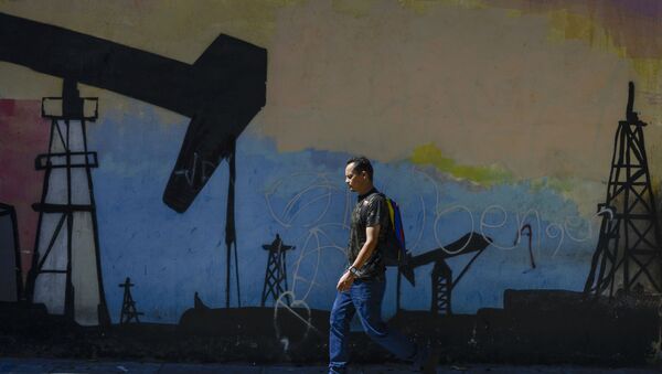Venesuela vətəndaşı Karakasda divarda neft buruğunun təsvir edildiyi qraffitinin yanından keçir - Sputnik Azərbaycan