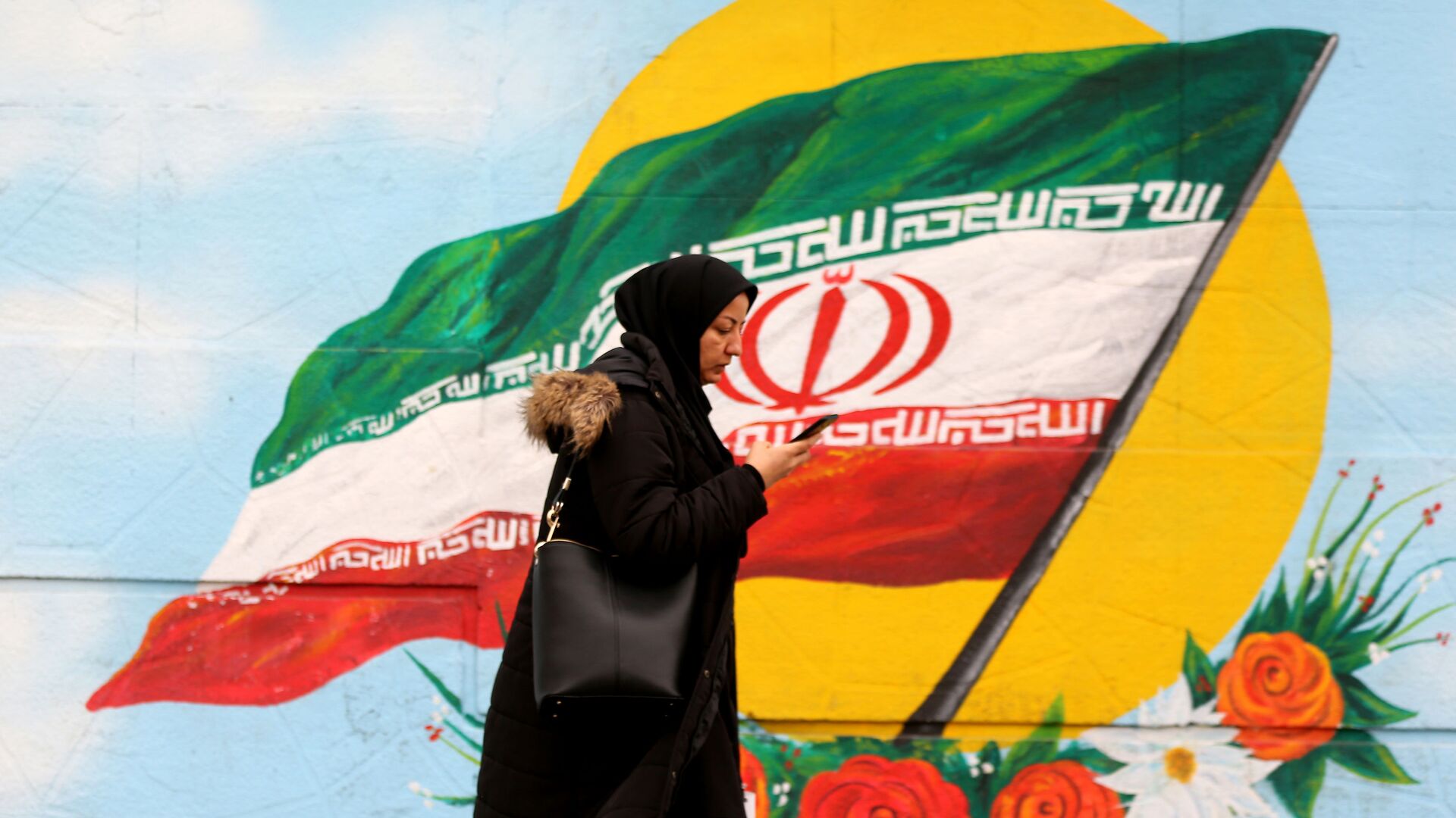 Женщина проходит перед фреской, на которой изображен иранский национальный флаг, фото из архива - Sputnik Азербайджан, 1920, 31.01.2023
