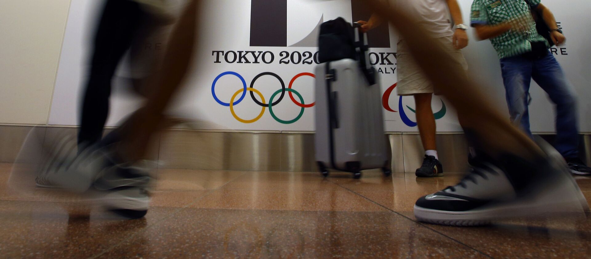 Туристы проходят мимо плаката с логотипом Олимпиады в Токио, фото из архива - Sputnik Азербайджан, 1920, 03.01.2021