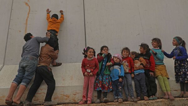 Сирийские дети пытаются перебраться через турецкую пограничную стену в северо-западной провинции Сирии - Sputnik Azərbaycan