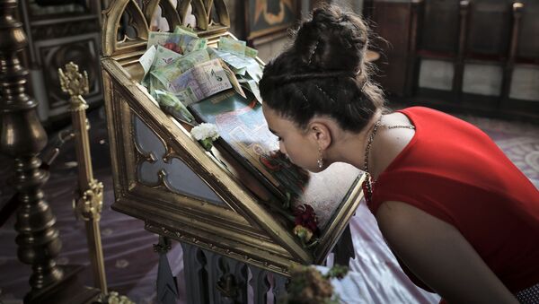 Девушка целует икону в церкви, фото из архива - Sputnik Azərbaycan