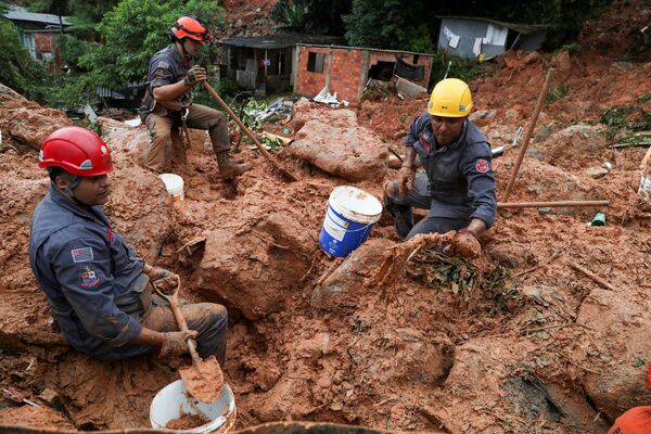 Спасатели ищут жертв оползня, вызванного проливными дождями в прибрежном городе Гуаружа, Бразилия - Sputnik Азербайджан