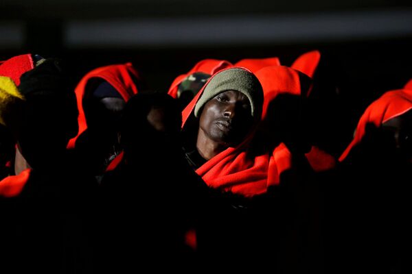 Мигранты ожидают высадки со спасательного катера в порту Малага, Испания - Sputnik Азербайджан