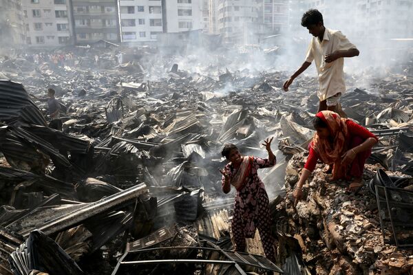 Slum dwellers search for their household items after a fire broke out in a slum in Dhaka, Bangladesh - Sputnik Азербайджан