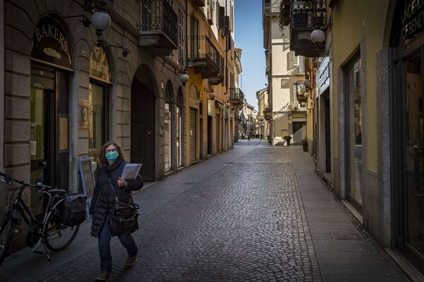 Женщина в маске но одной из улиц Новары, Италия - Sputnik Азербайджан